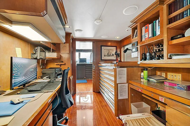 a room with a computer and bookshelves aboard MAVERICK Yacht for Charter
