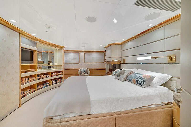 a bedroom with a bed and a bookcase aboard MAVERICK Yacht for Charter