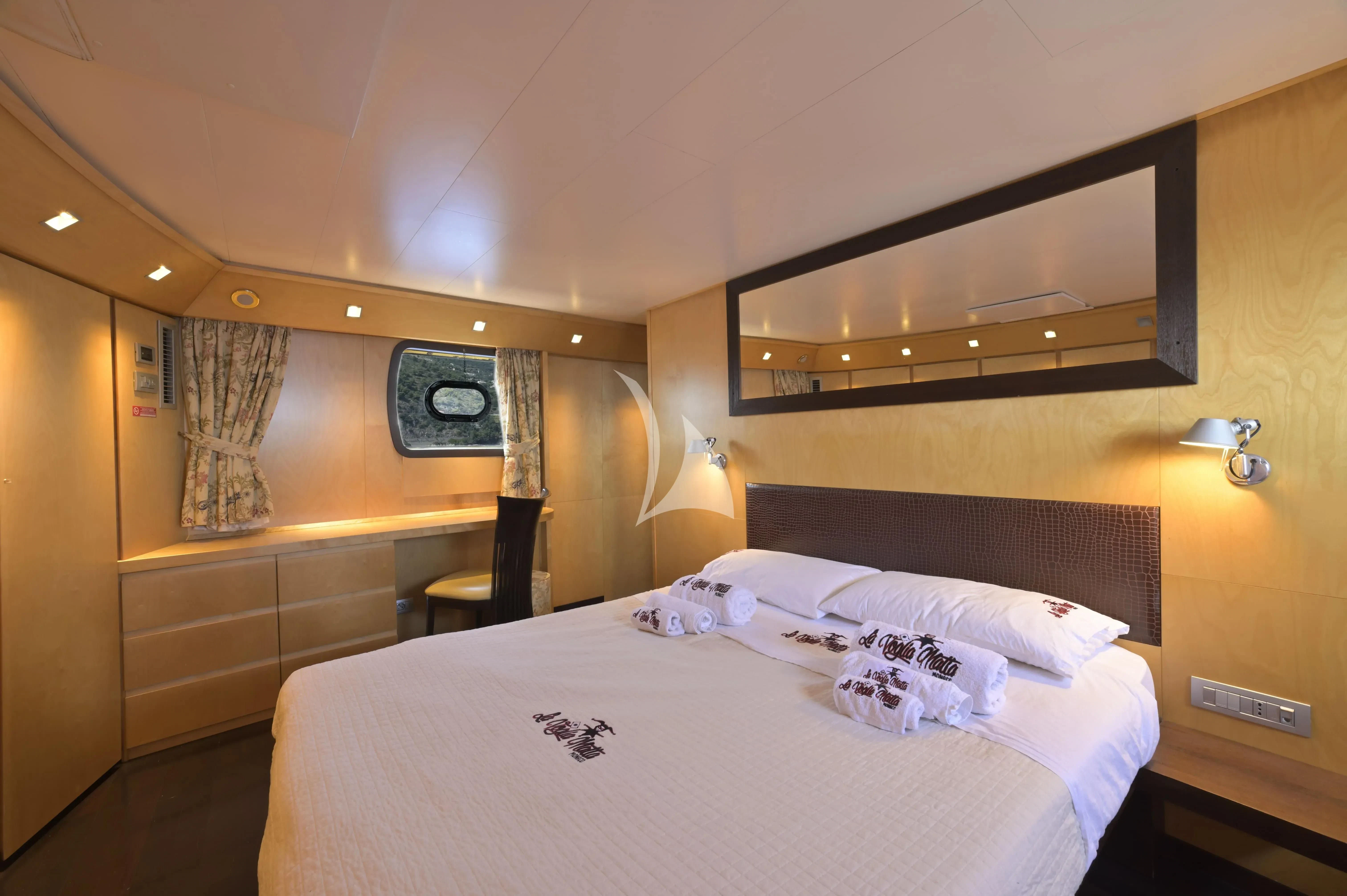 a room with a bed and a chair aboard LA VOGLIA MATTA Yacht for Charter