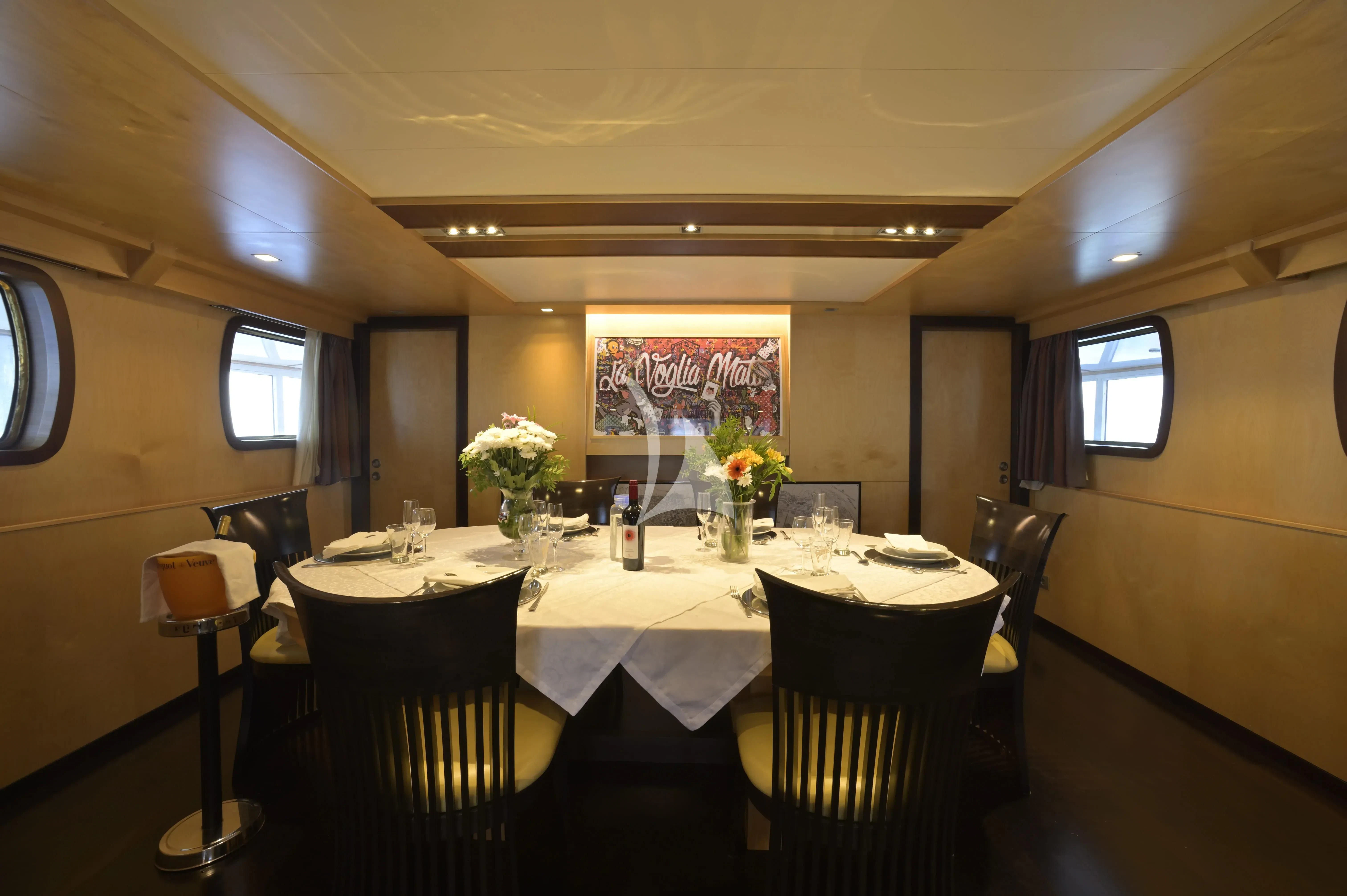 a dining room with tables and chairs aboard LA VOGLIA MATTA Yacht for Charter