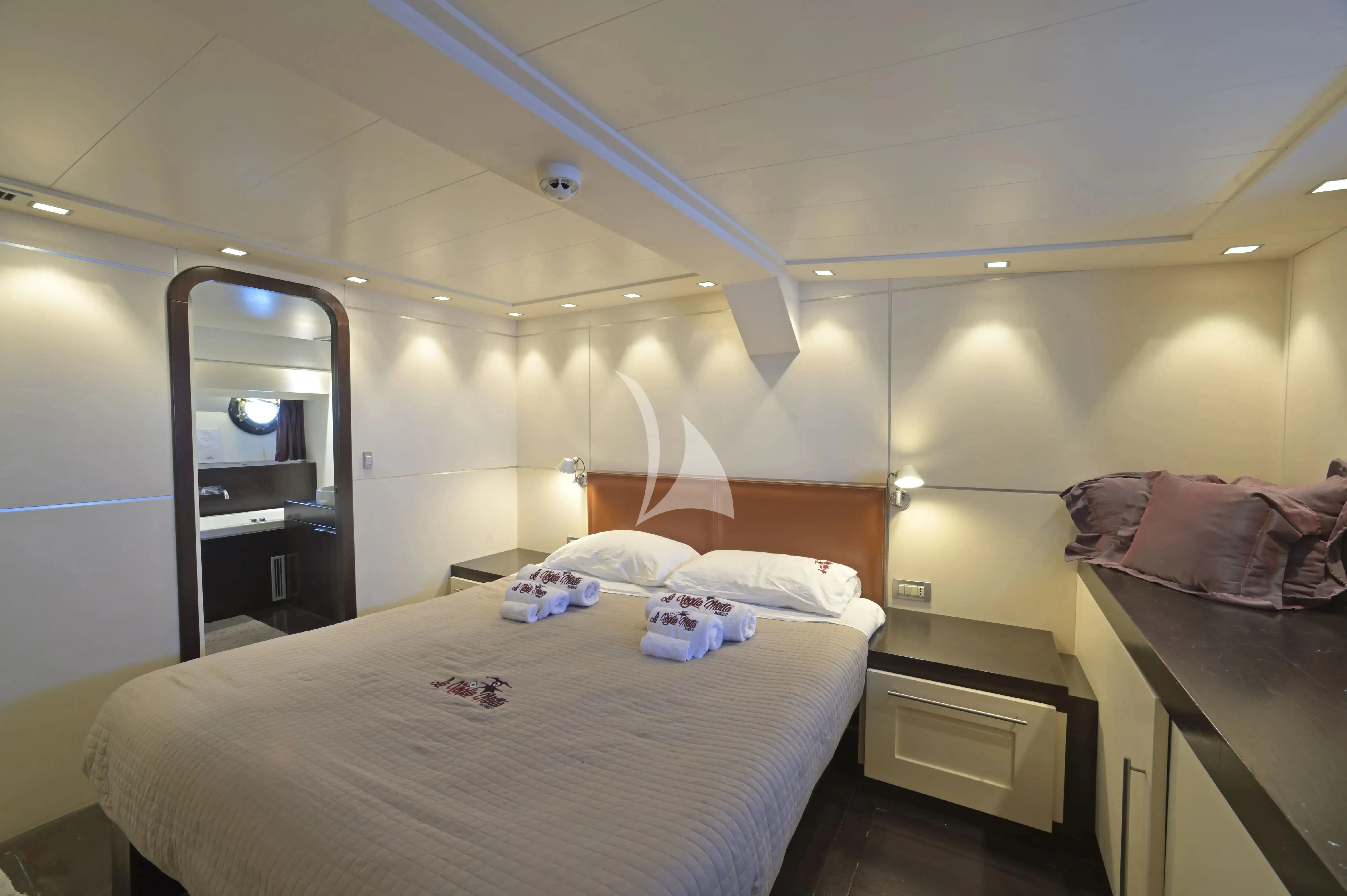 a room with a bed and a mirror aboard LA VOGLIA MATTA Yacht for Charter