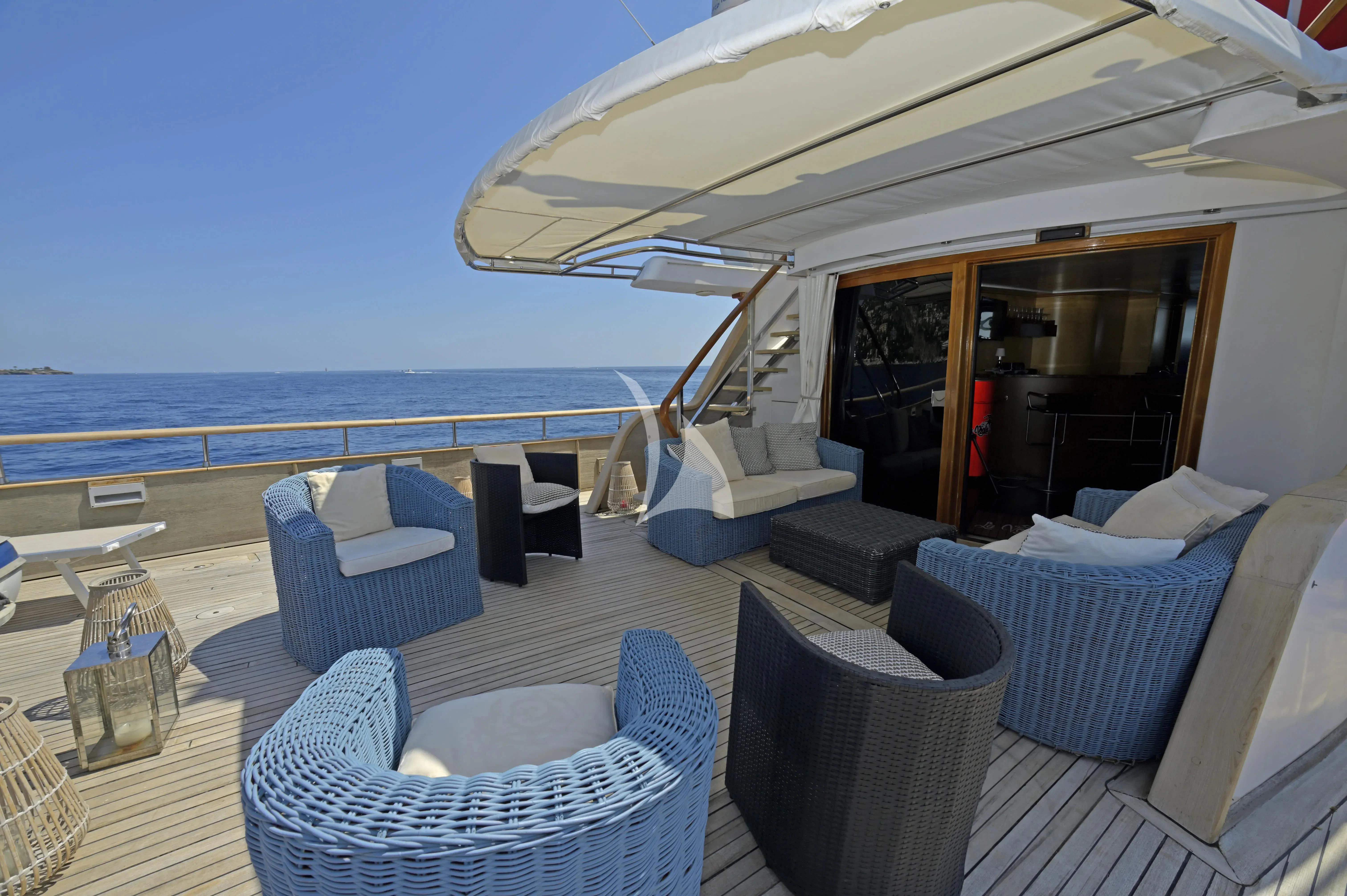 a large lounge area with a large umbrella over it aboard LA VOGLIA MATTA Yacht for Charter