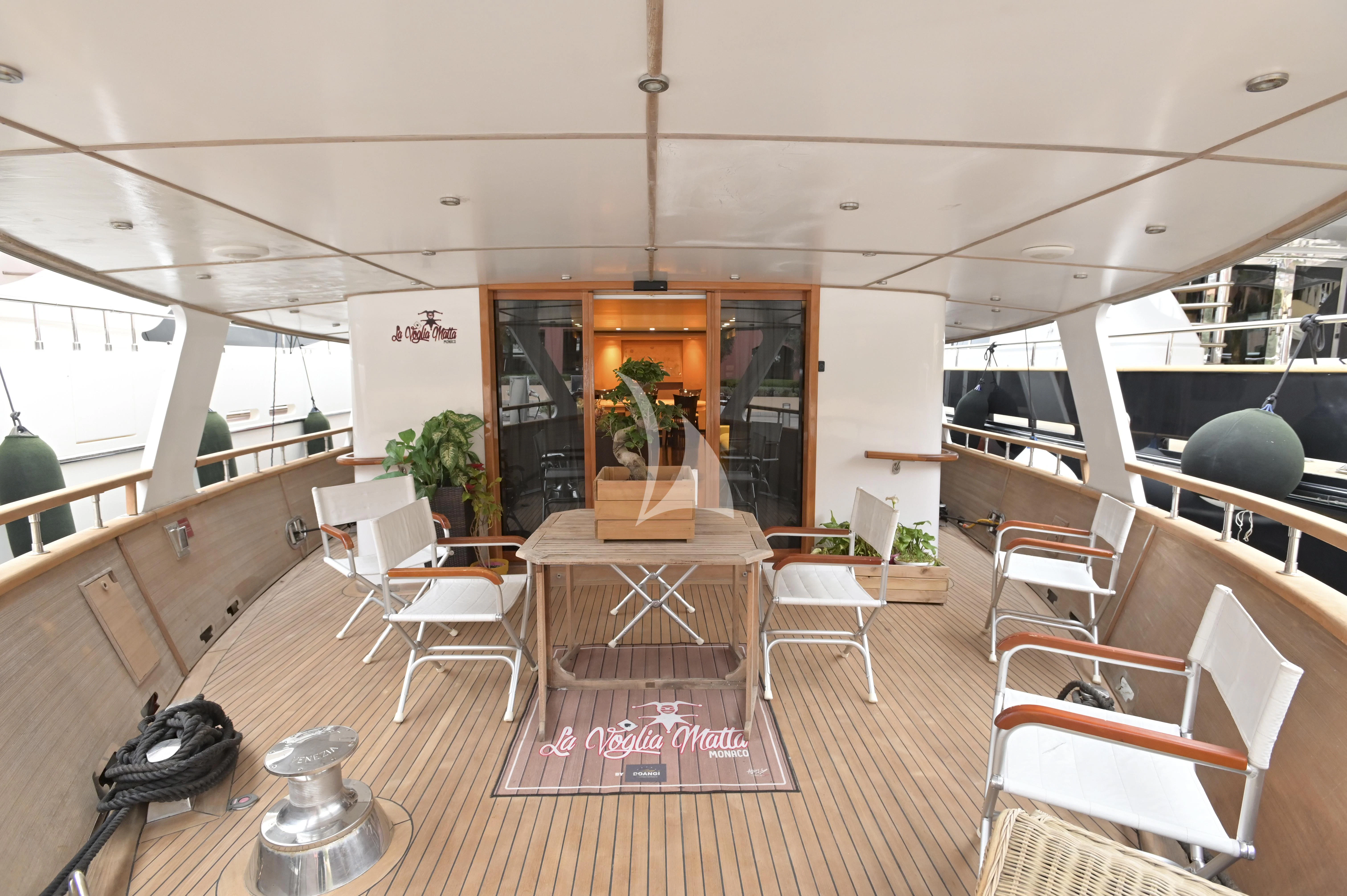 a room with tables and chairs aboard LA VOGLIA MATTA Yacht for Charter