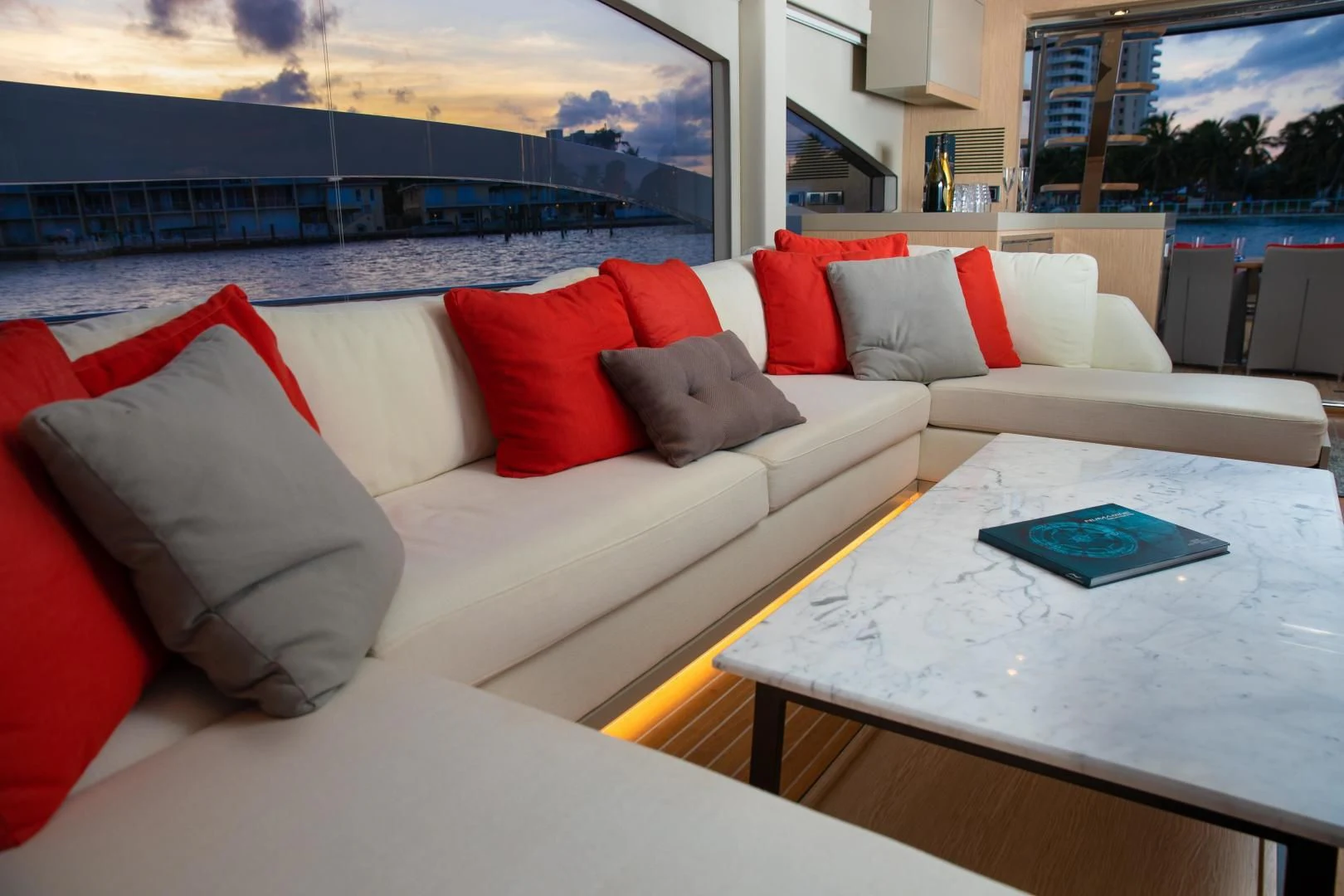 a white couch with red pillows aboard ADONIS Yacht for Sale