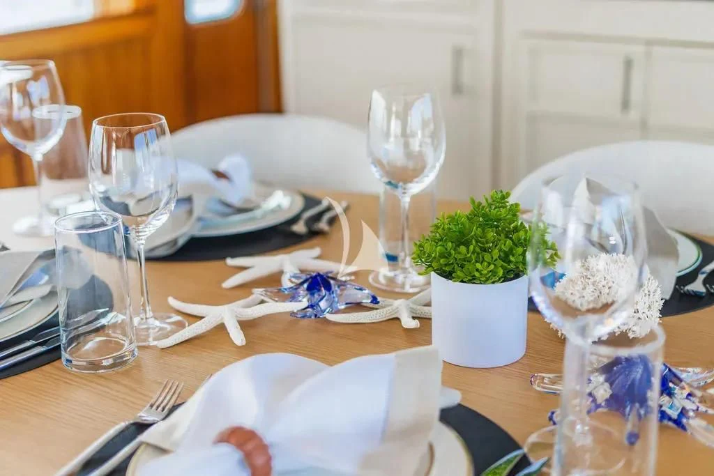 a table with plates and glasses aboard CARPE DIEM Yacht for Charter