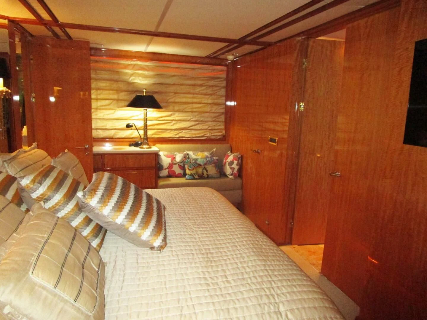 a bedroom with a bed and a wood cabinet aboard CARPE DIEM Yacht for Charter