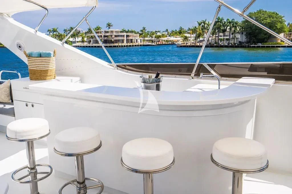 a white table with stools on it next to a body of water aboard CARPE DIEM Yacht for Charter