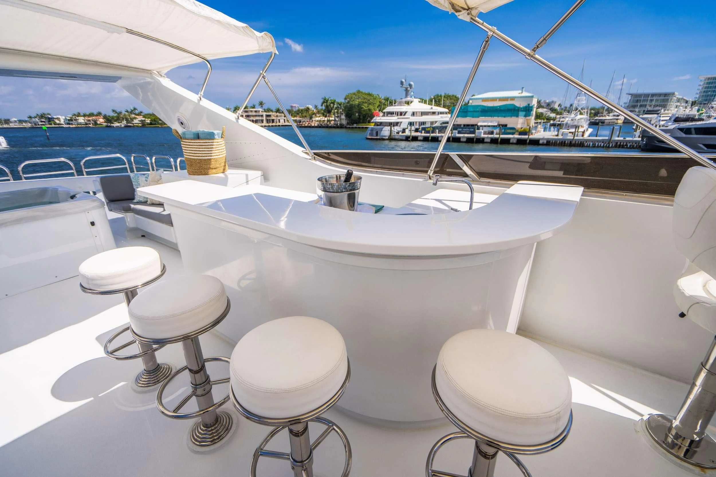 a white boat with stools on a deck by a body of water aboard CARPE DIEM Yacht for Charter