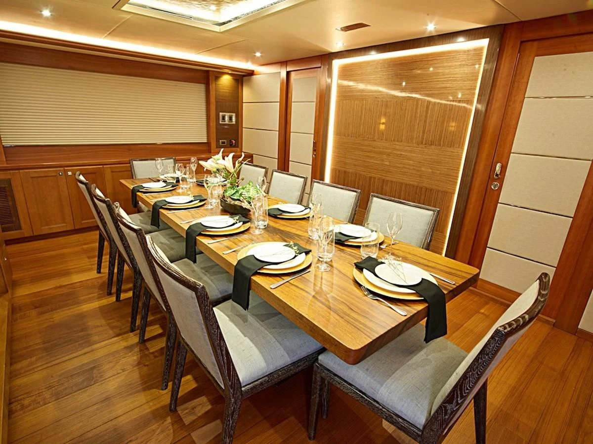a dining room table set for a dinner party aboard ALAIA Yacht for Sale