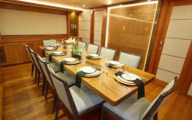 a dining room table set for a dinner party aboard ALAIA Yacht for Sale
