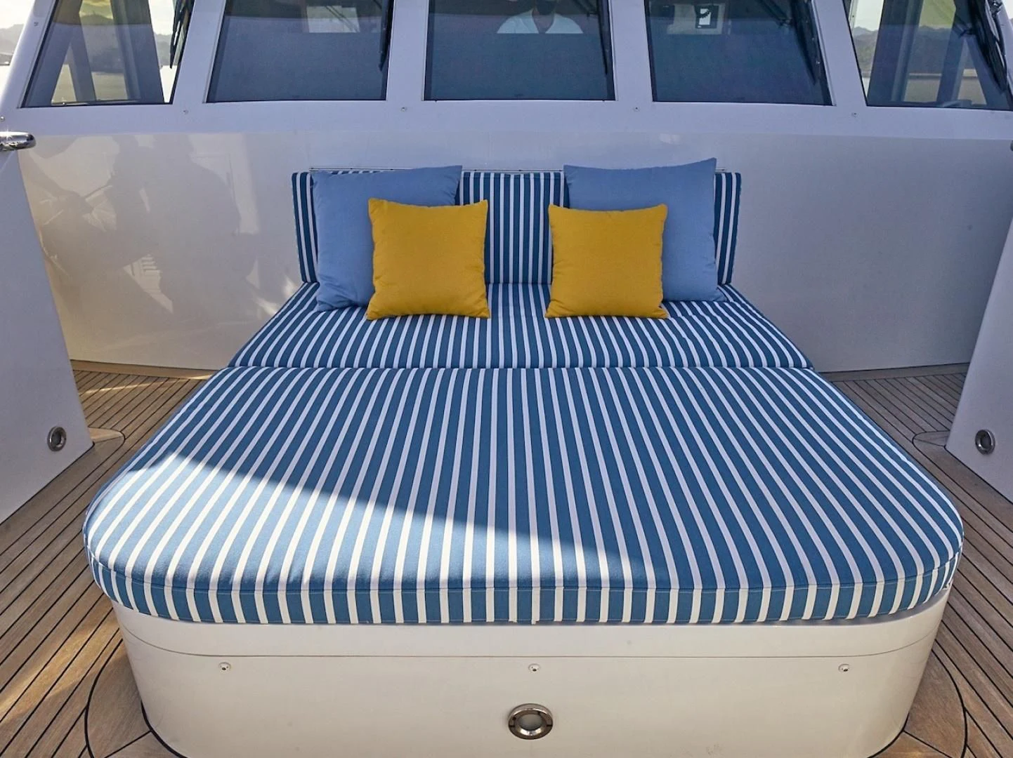 a bed with blue and white striped sheets aboard ALAIA Yacht for Sale