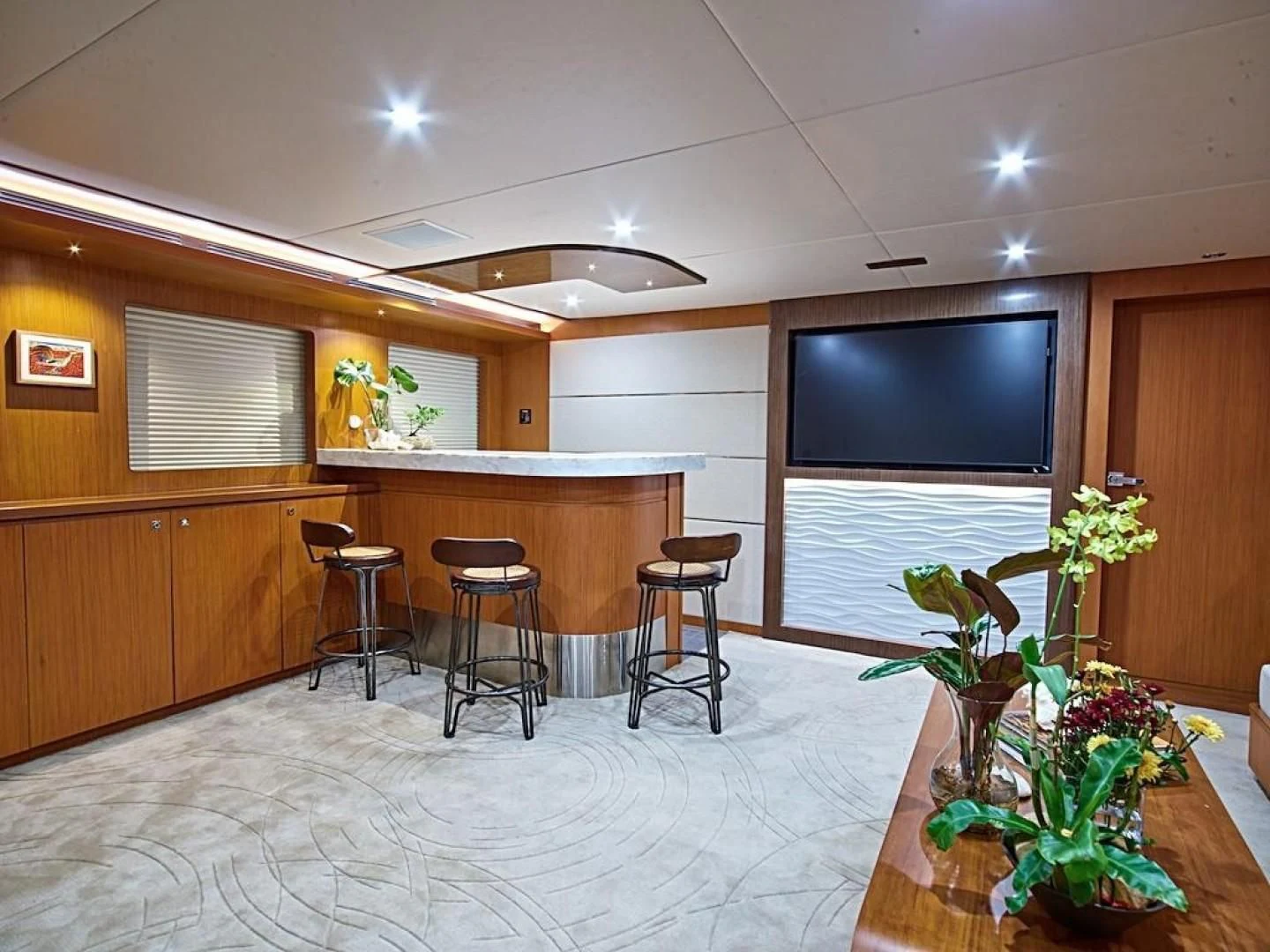 a large room with a tv and chairs aboard ALAIA Yacht for Sale