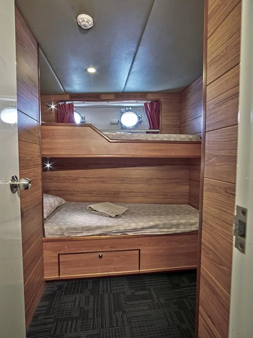 a wooden bunk bed aboard ALAIA Yacht for Sale