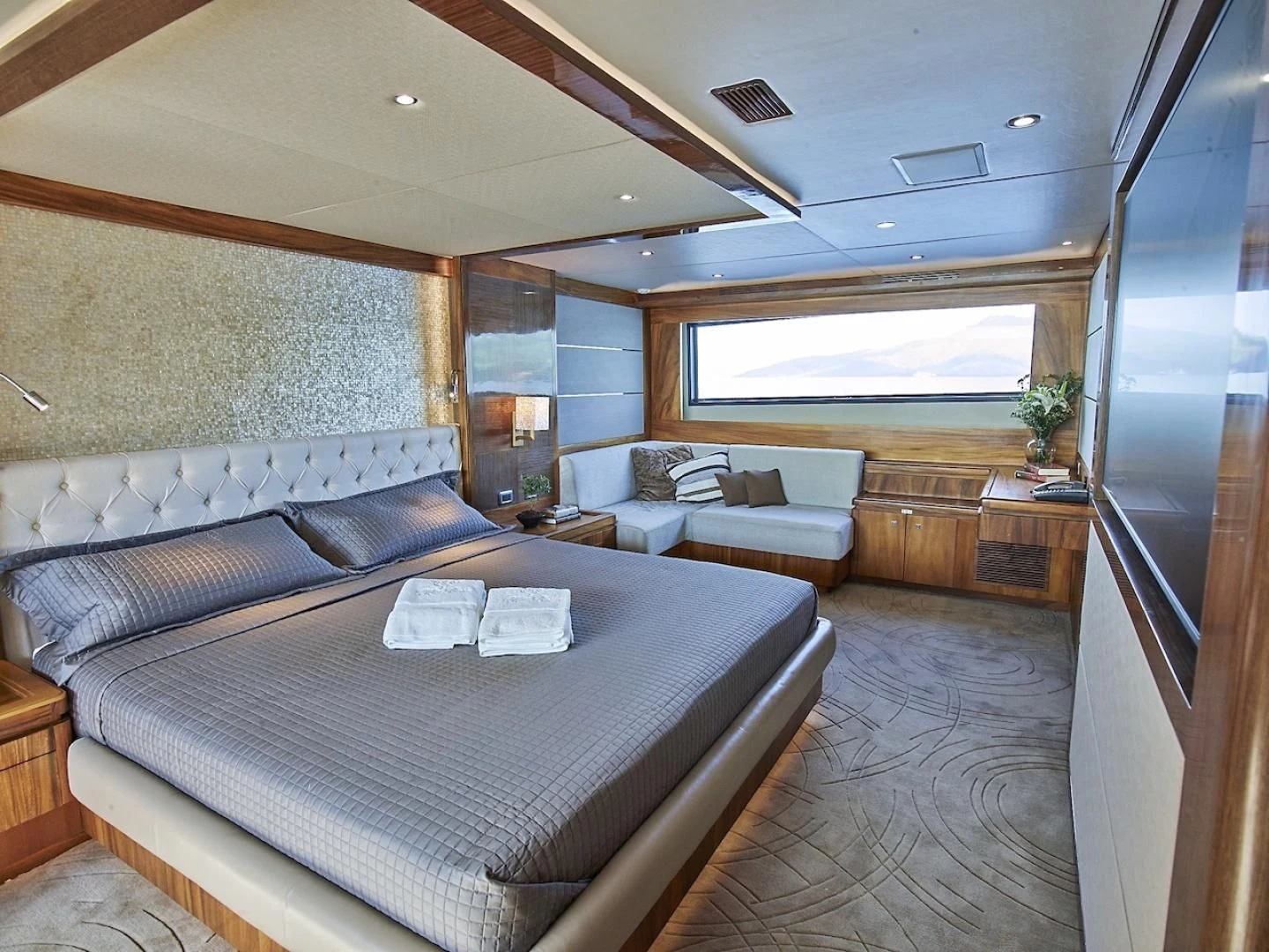 a large bedroom with a bed and a couch aboard ALAIA Yacht for Sale