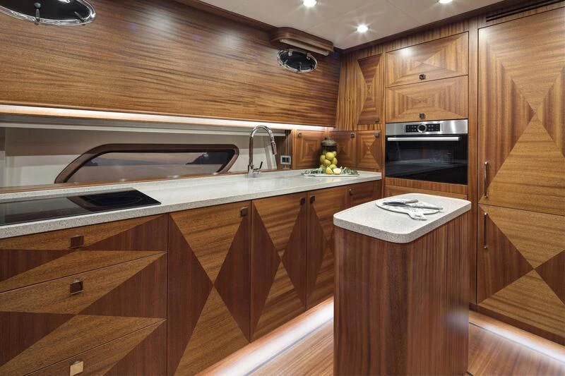 a kitchen with wooden cabinets aboard ALECTO Yacht for Sale