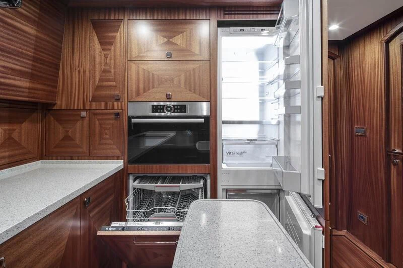 a kitchen with wooden cabinets aboard ALECTO Yacht for Sale