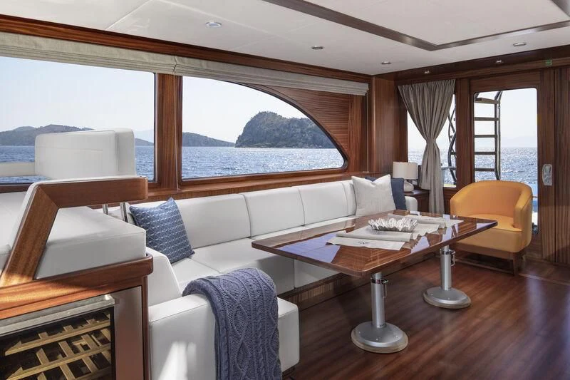 a room with a couch and a table and a window aboard ALECTO Yacht for Sale