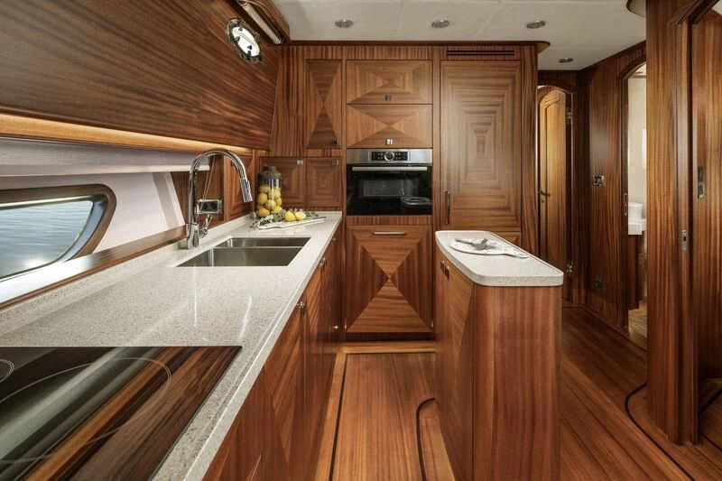 a kitchen with wooden cabinets aboard ALECTO Yacht for Sale