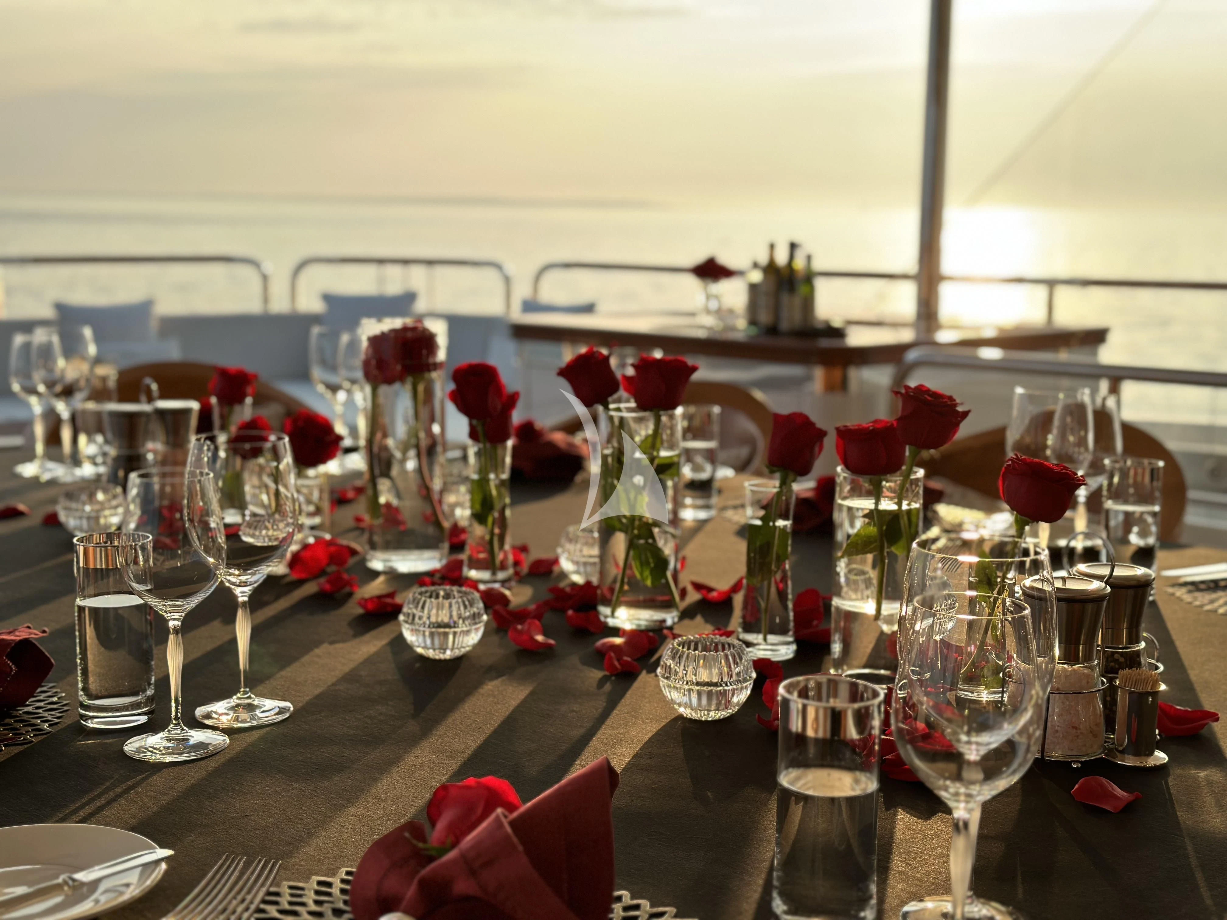 a table with glasses and flowers aboard ROCK.IT Yacht for Charter