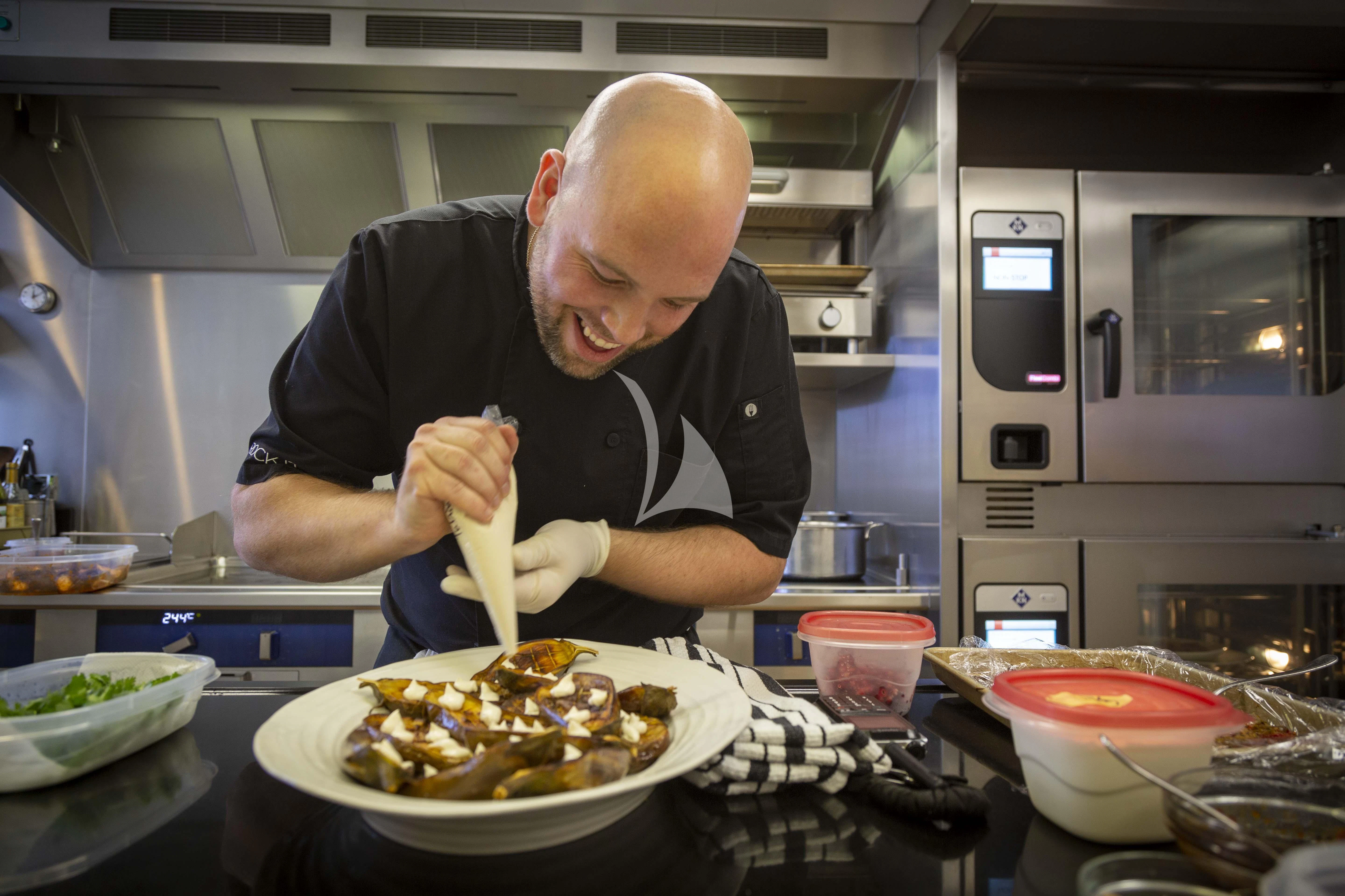a person making a pizza aboard ROCK.IT Yacht for Charter