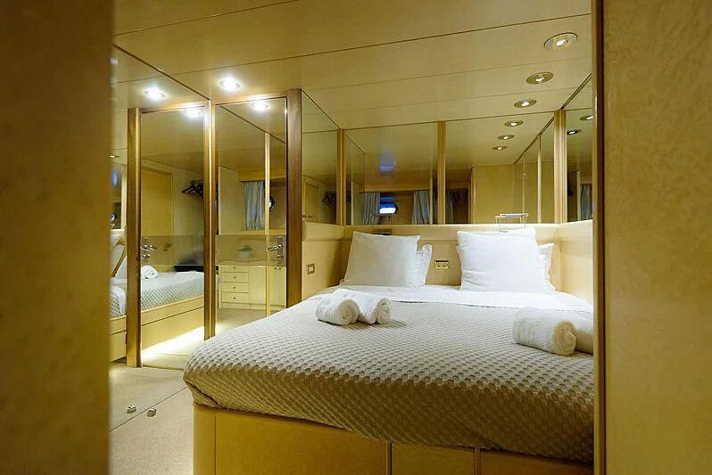 a bed with a white bed spread aboard LADY RINA Yacht for Sale
