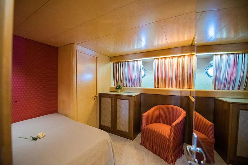 a room with a bed and a chair aboard LADY RINA Yacht for Sale