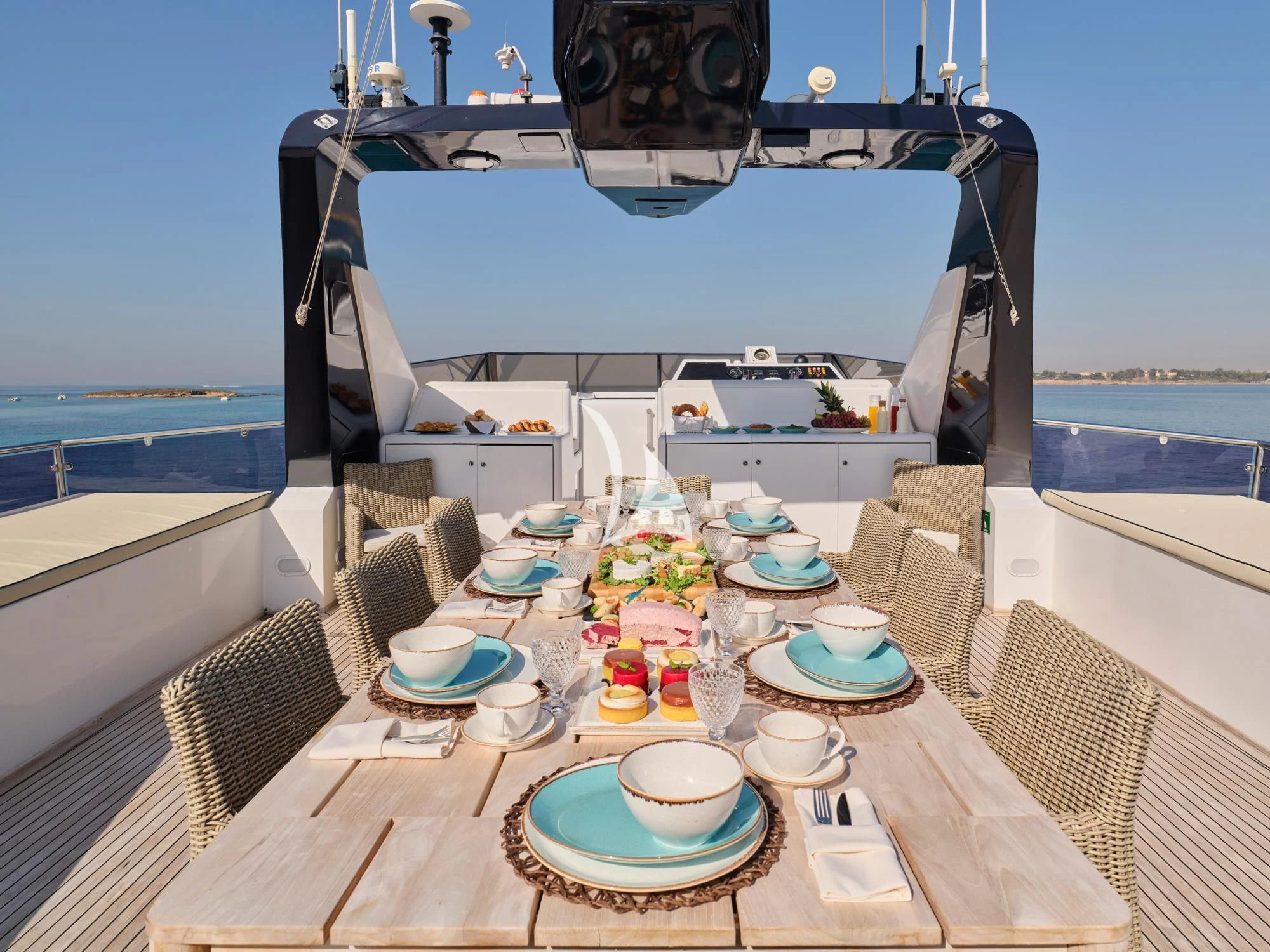 a table with plates and cups on it next to a large boat aboard LADY RINA Yacht for Sale