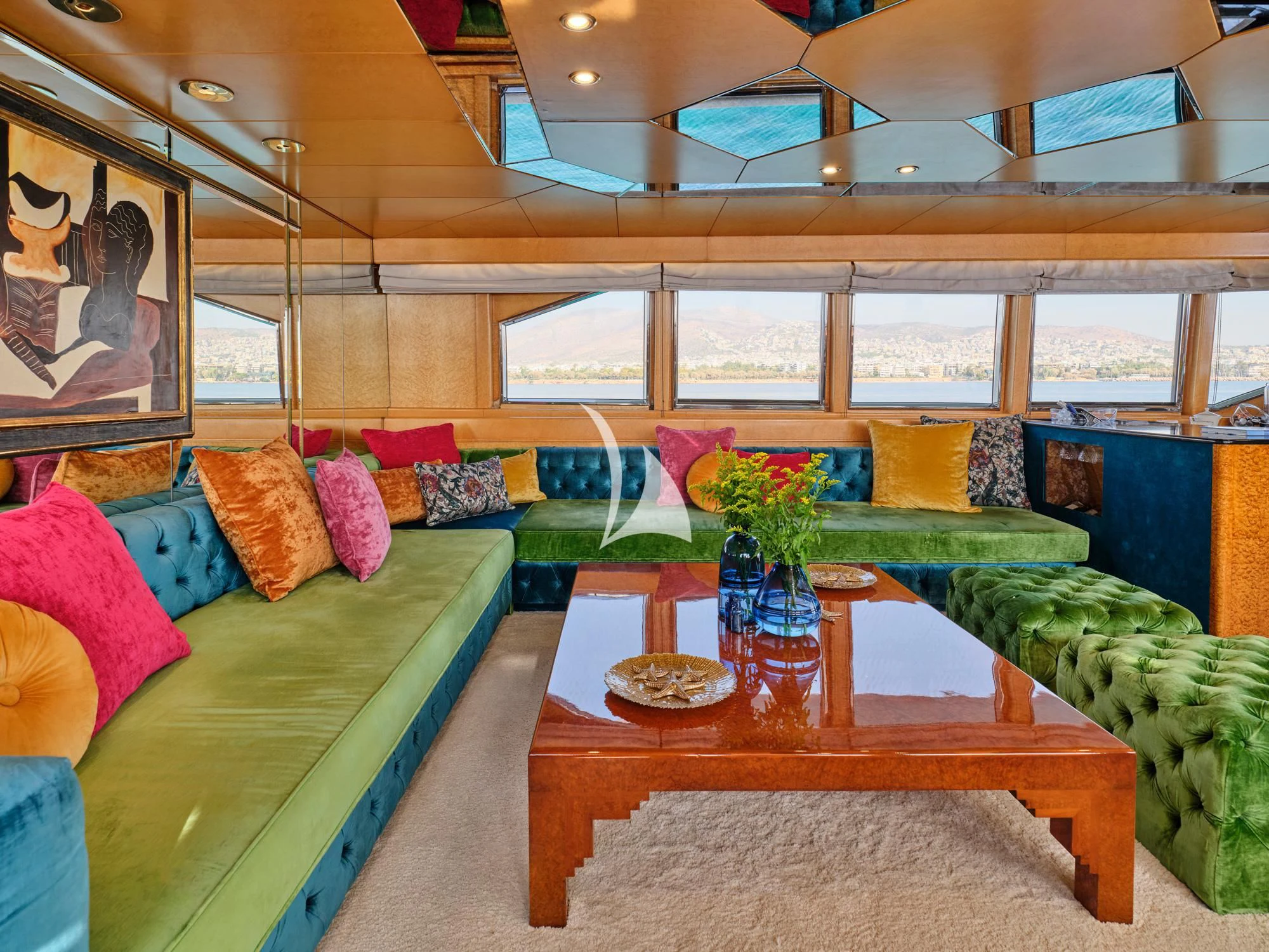 a room with a couch and a table with a vase of flowers aboard LADY RINA Yacht for Sale