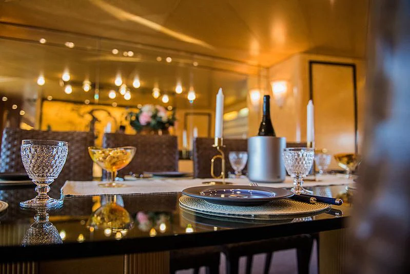 a table with plates and glasses on it aboard LADY RINA Yacht for Sale