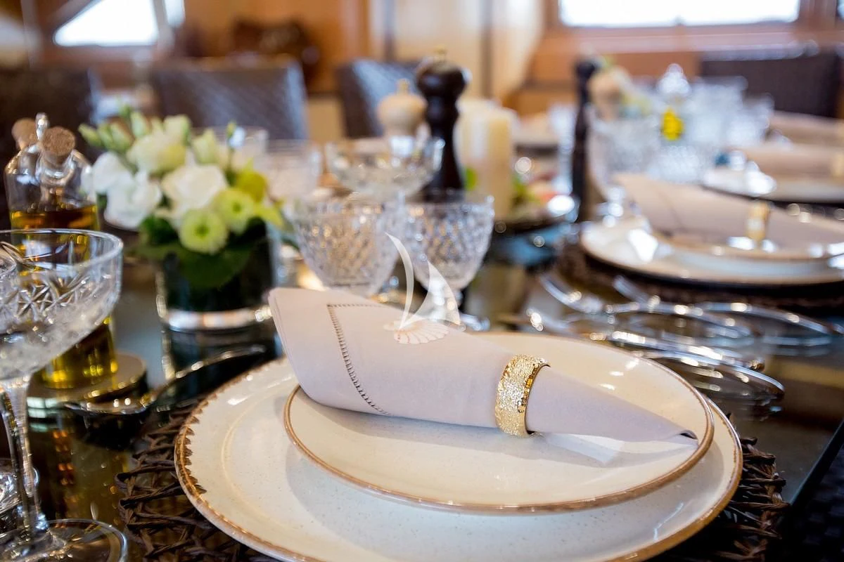 a table with plates and glasses aboard LADY RINA Yacht for Sale