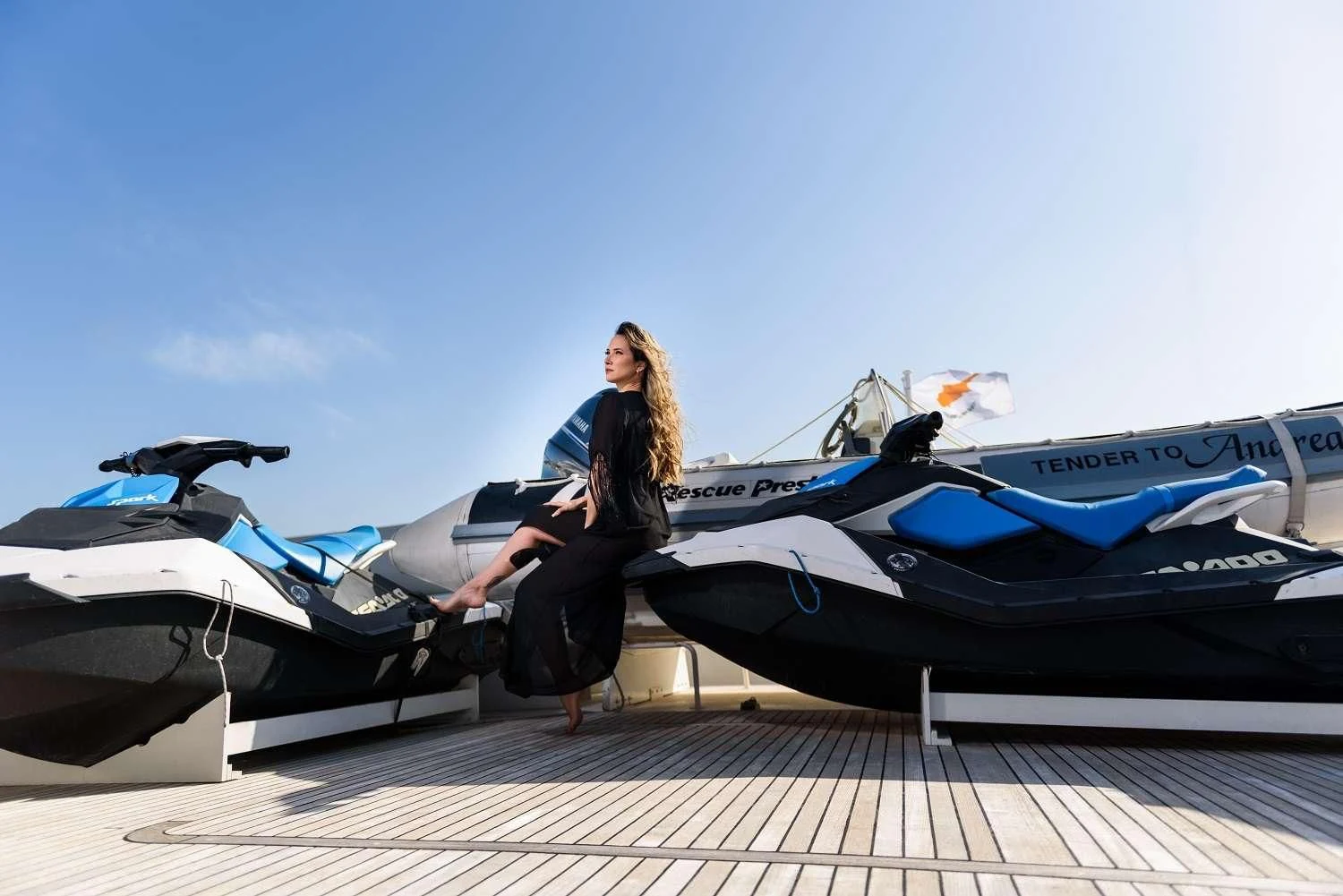 a person sitting on a deck next to several airplanes aboard LADY RINA Yacht for Sale