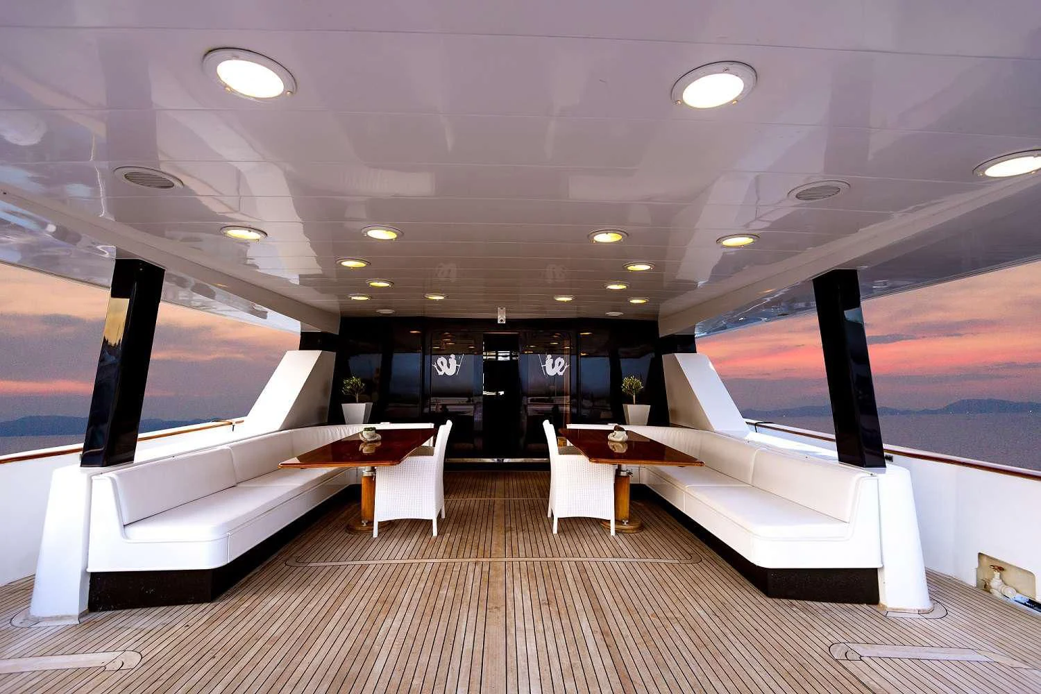 a room with a large white bed and a table with chairs aboard LADY RINA Yacht for Sale