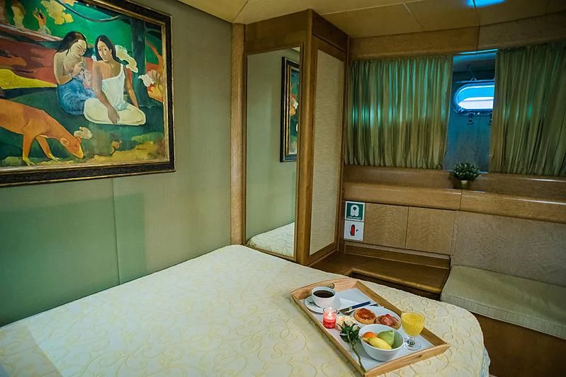 a room with a bed and a table with food on it aboard LADY RINA Yacht for Sale