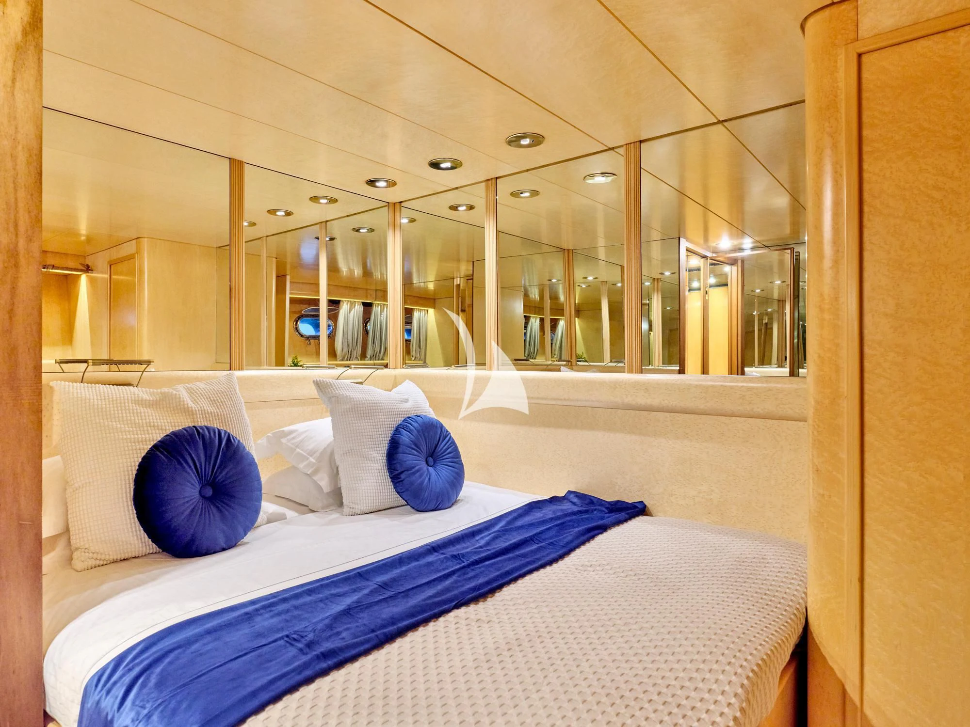 a bed with blue pillows aboard LADY RINA Yacht for Sale