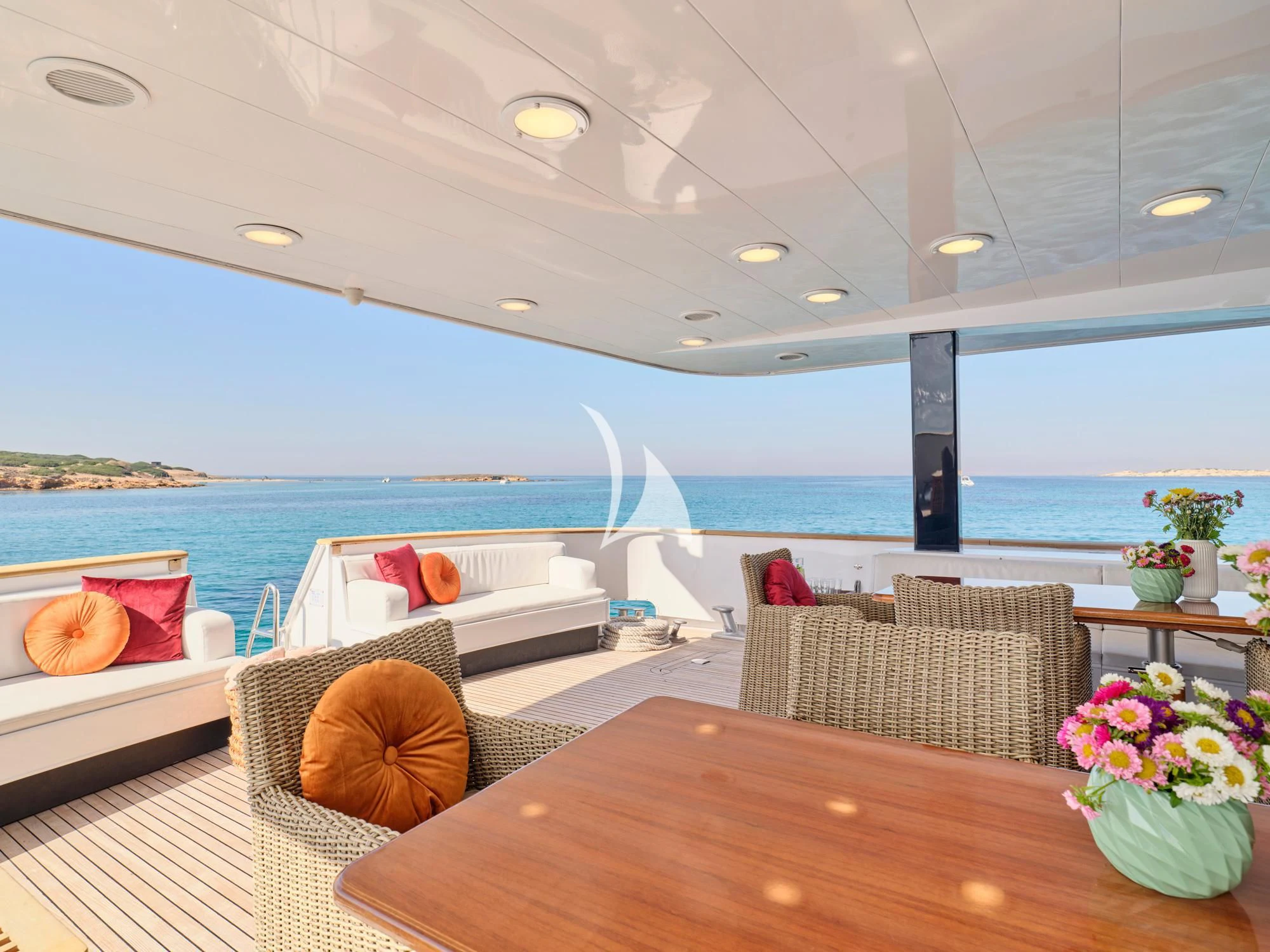 a table and chairs on a deck overlooking a body of water aboard LADY RINA Yacht for Sale
