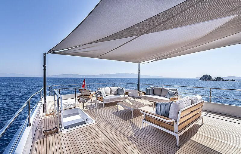 a deck with chairs and a body of water in the background aboard TUBABU Yacht for Sale