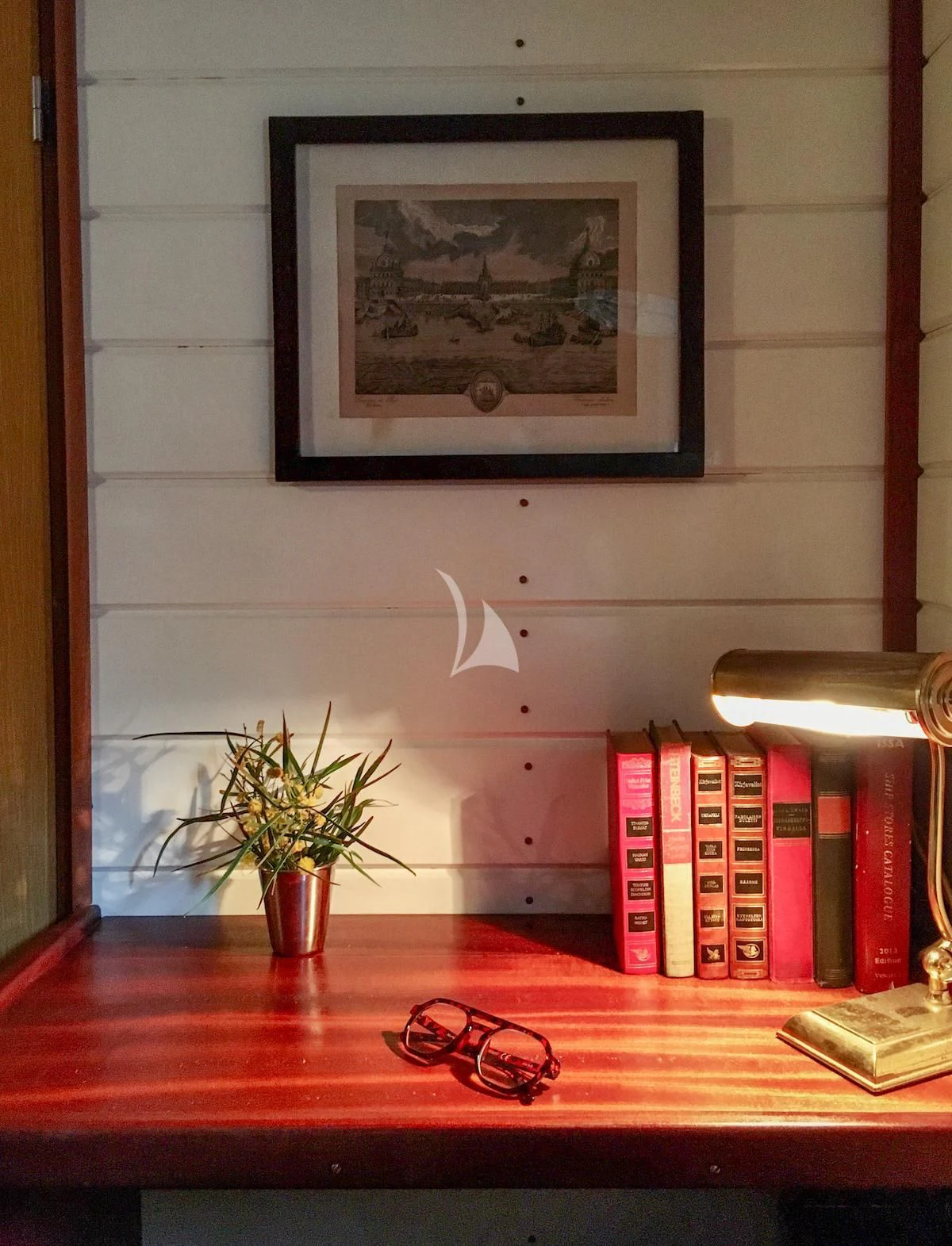 a desk with books and a picture on it aboard BALTO Yacht for Sale