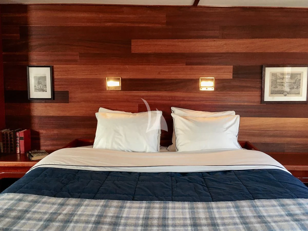 a bed with white pillows aboard BALTO Yacht for Sale