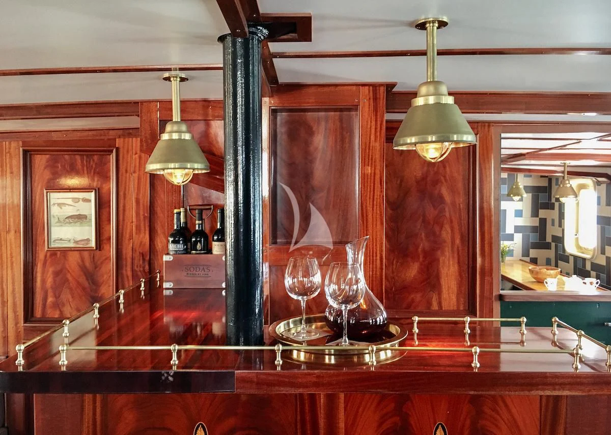 a glass display case with a few glasses on a table aboard BALTO Yacht for Sale