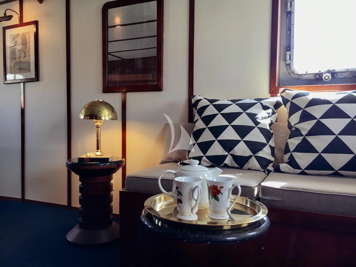 a coffee table with a lamp and a vase on it aboard BALTO Yacht for Sale