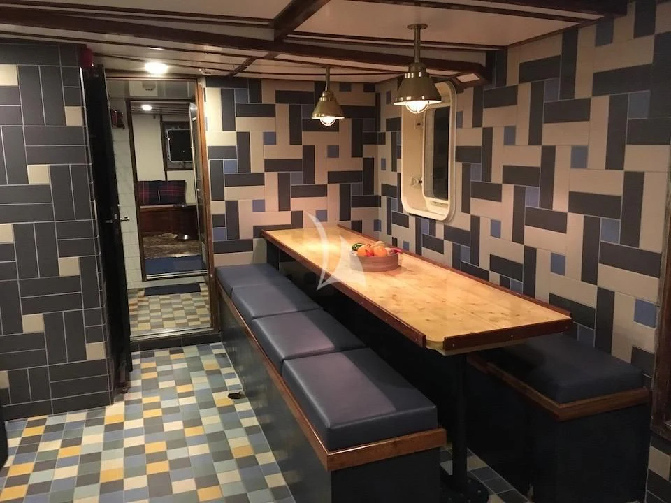 a room with a table and chairs aboard BALTO Yacht for Sale