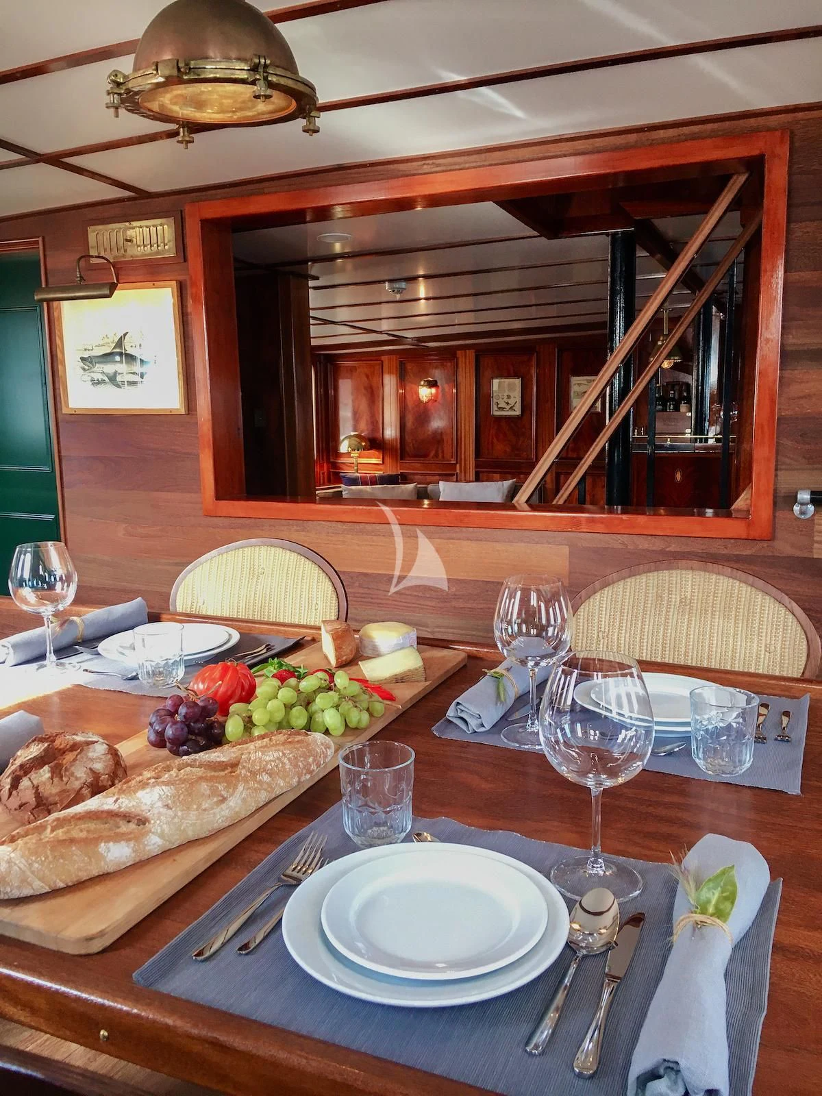 a table with plates and glasses aboard BALTO Yacht for Sale