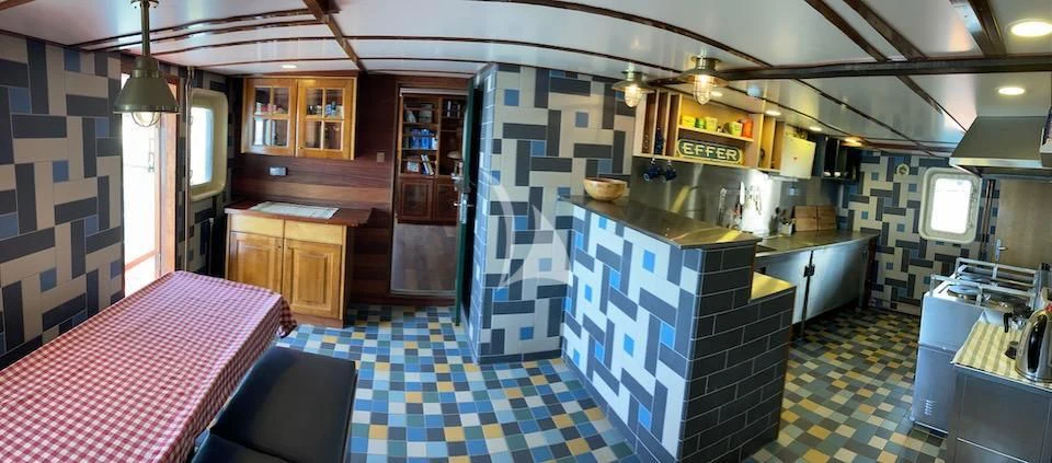 a kitchen with a checkered table cloth aboard BALTO Yacht for Sale