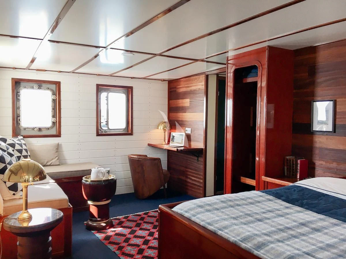 a bedroom with a bed and a desk aboard BALTO Yacht for Sale