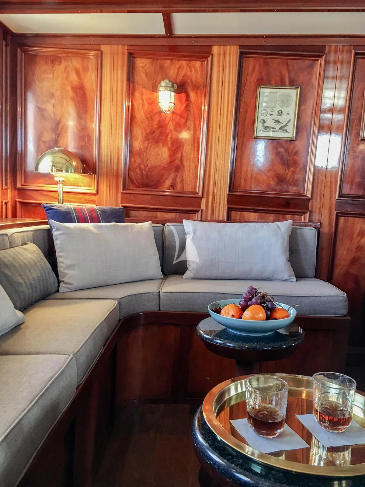 a couch with a bowl of fruit on it aboard BALTO Yacht for Sale