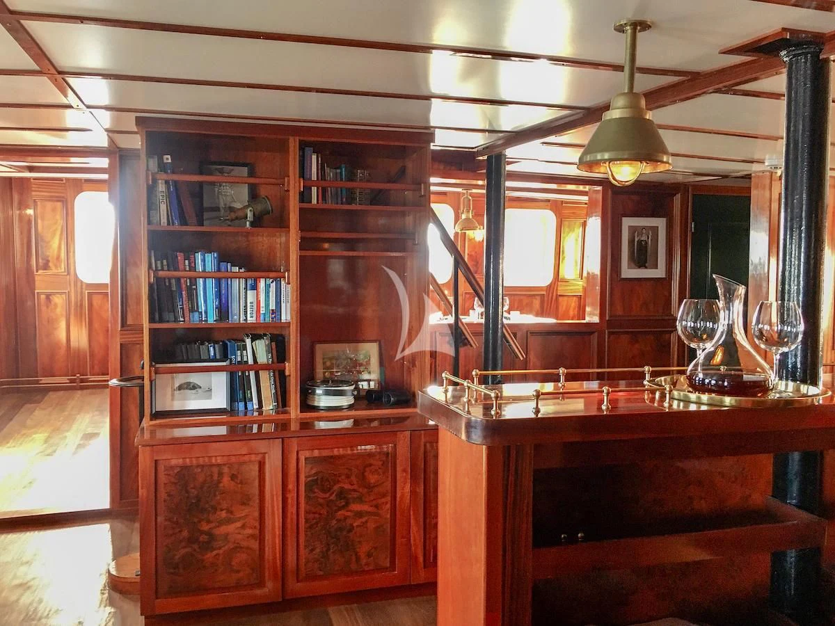 a room with a table and wine glasses aboard BALTO Yacht for Sale