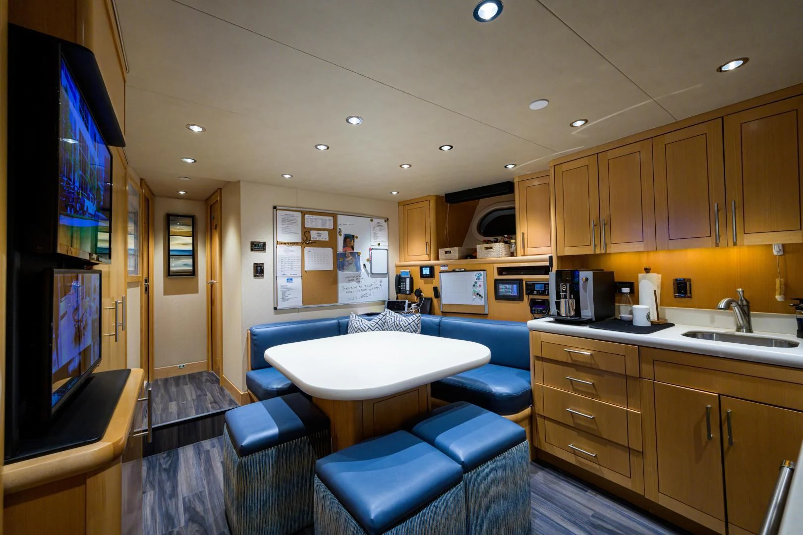 a kitchen with a tv and a table aboard LADY JJ Yacht for Charter
