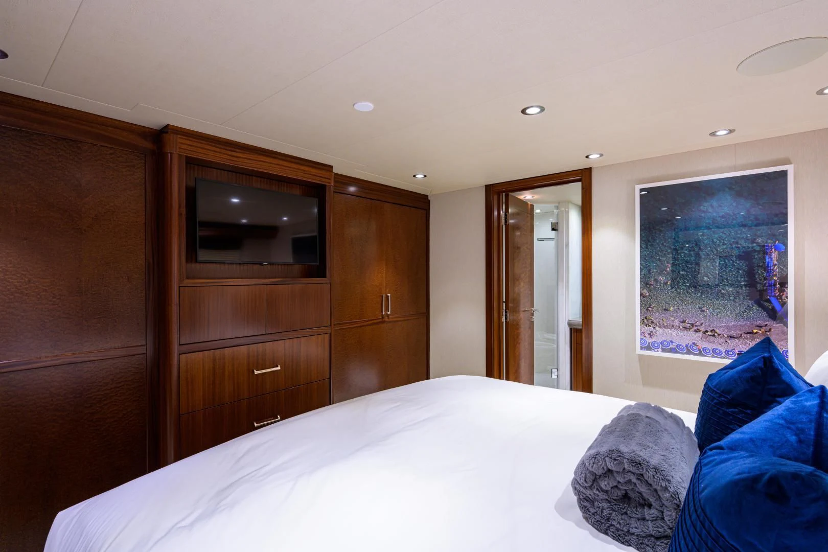 a bedroom with a bed and a wood cabinet aboard LADY JJ Yacht for Charter