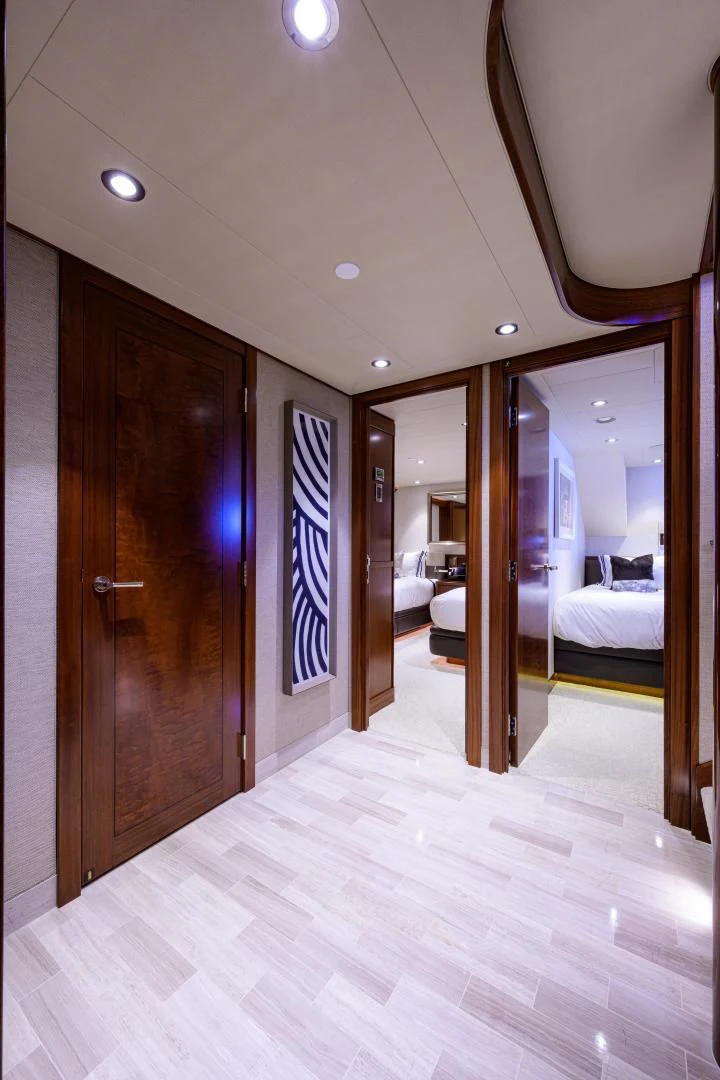a room with a wood door and a mirror with a white and blue striped wall and a white aboard LADY JJ Yacht for Charter