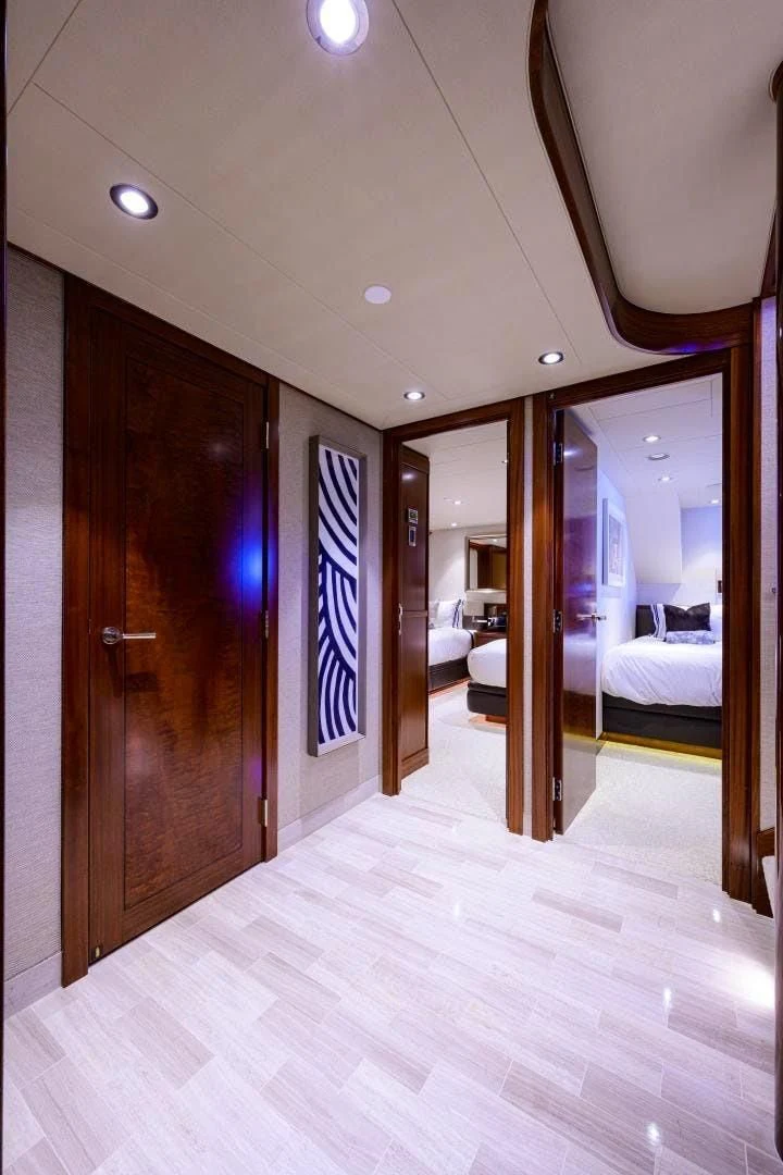 a room with a wood door and a mirror with a blue and white striped wall aboard LADY JJ Yacht for Charter